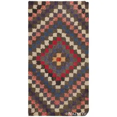 This superb antique American hooked rug is an artful record of the country humble cultural patterns...