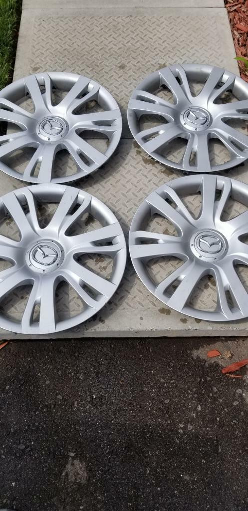 MAZDA    FACTORY OEM 15 INCH WHEEL COVER SET OF FOUR IN GOOD   CONDITION in Tires & Rims in Ontario