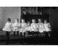 Buyenlarge Seven Toddlers in White Dresses Seated on Bench - Photograph Print